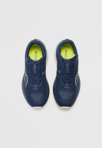 Zapatillas deportivas azul marino con parte superior de malla, cordones texturizados, plantillas de un verde brillante y suelas de goma blanca. Presenta el logotipo en el lado.