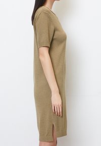 Knit dress in light olive green with short sleeves, ribbed cuffs, and a side slit at the hem. Soft texture and relaxed fit.