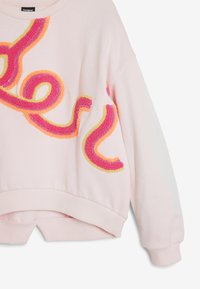 Felpa rosa chiaro con un design applicato testurizzato e colorato in rosa, arancione e giallo. Polsini e orlo a coste, vestibilità leggermente accorciata.