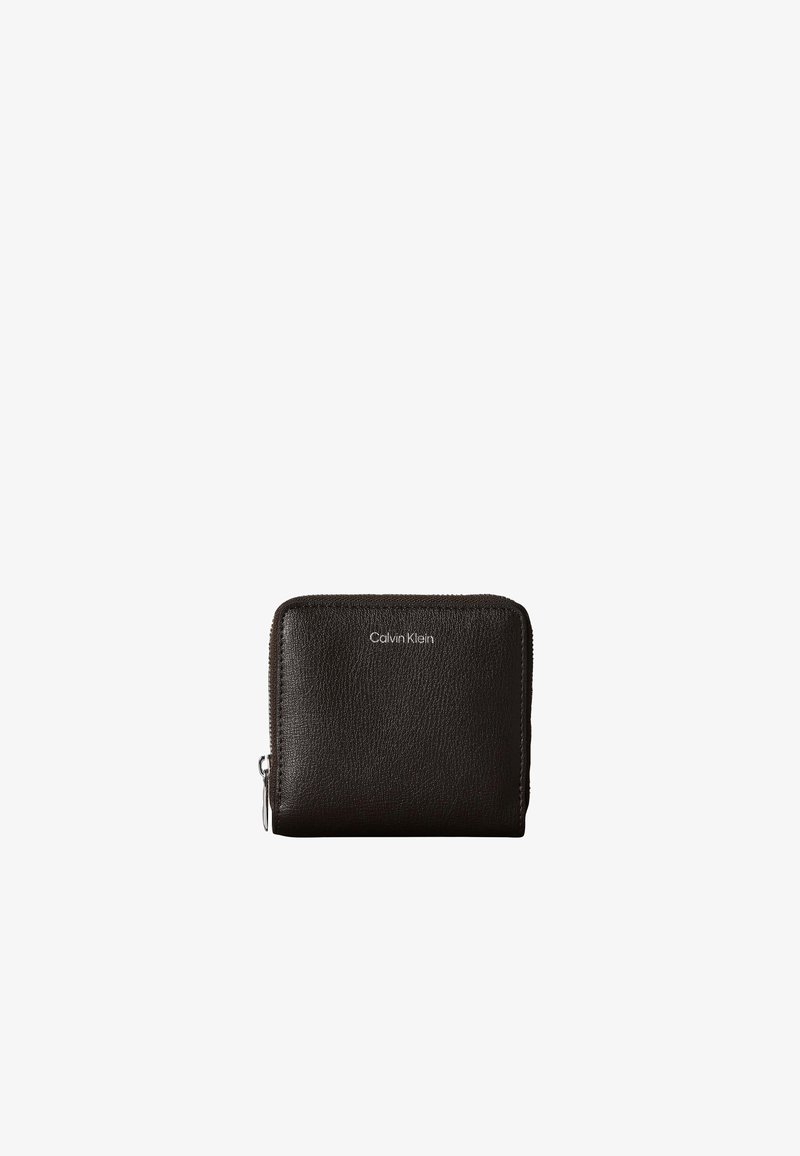 Portefeuille compact en cuir noir avec une fermeture éclair argentée et un petit logo Calvin Klein au centre devant.