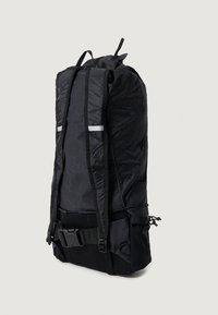 Schwarzer Rucksack aus Nylon mit strukturiertem Design, der über verstellbare Riemen, einen Netzrücken und reflektierende Akzente verfügt.