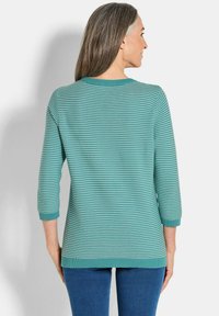 Tee-farbig gestreifter Pullover mit Rundhalsausschnitt und Dreiviertelärmeln. Gerippte Bündchen und Saum, weiche Textur, lässige Passform.