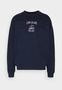 Sudadera azul marino hecha de una mezcla de algodón, con un cuello redondo, puños acanalados y un diseño bordado de un faro con texto.
