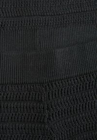 Mustavalmistettu kangas, jossa on tekstuuri, joka näyttää vuorotellen tiukkoja ja löysiä ompeleita. Sujuva pinta, jolla on pehmeä ilme.