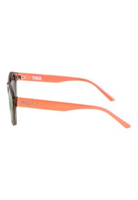 Aurinkolasit tumman läpikuultavan kehykset, vihreät linssit ja kirkkaat oranssit kumikahvat, joissa on "ROXY" ja "TIKA" -brändäys.