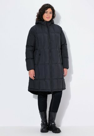 Black puffer coat with a hood, featuring a quilted design, zip closure, and side pockets. Worn over dark jeans and black leather boots.