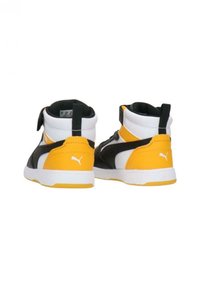 Scarpe sportive high-top che presentano una combinazione di materiali bianchi, neri e gialli, con accenti testurizzati e un colletto imbottito.
