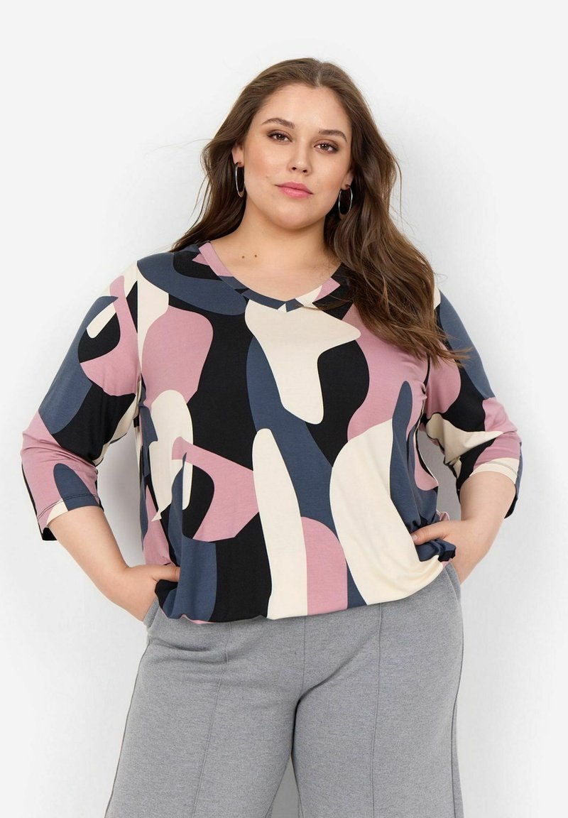 Top dai colori vivaci con forme astratte nei toni di rosa, nero e crema, con scollatura a V e maniche a tre quarti. Tessuto morbido al tatto.