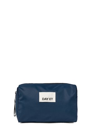 Navy blue fabric cosmetics bag with zip closure, rectangular shape, featuring a front label with "DAY ET" in white text.