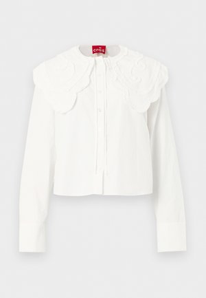 Bluză albă cu mâneci lungi, cu guler mare brodat cu margini ondulate și închidere frontală cu nasturi, expusă pe un fundal simplu.