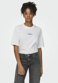 Witte katoenen T-shirt met korte mouwen en ronde hals. Heeft een blauw en rood tekstgrafiek "BEACH BRAZIL ESSENCE" op de voorkant.