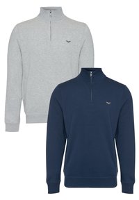 Twee zip-neksweaters: één grijs, één marineblauw. Beide hebben lange mouwen, ribgebreide manchetten en onderkanten, en een klein logo op de borst.