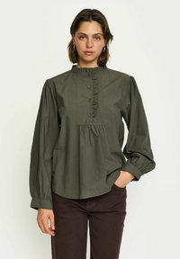 Blusa verde oliva a maniche lunghe con collo alto arricciato, chiusura frontale con bottoni e dettagli arricciati sulle spalle e sull'orlo.