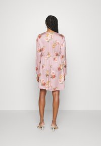 Vestido floral rosa com mangas longas, cintura elástica e comprimento até ao joelho. Textura suave com padrões de rosas multicoloridas.