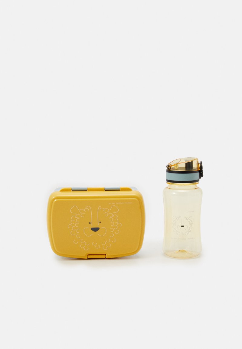 Žlutá svačinová krabička s designem lví tváře a průhledná láhev na vodu s odpovídající ilustrací lva. Obě části mají moderní tvary.