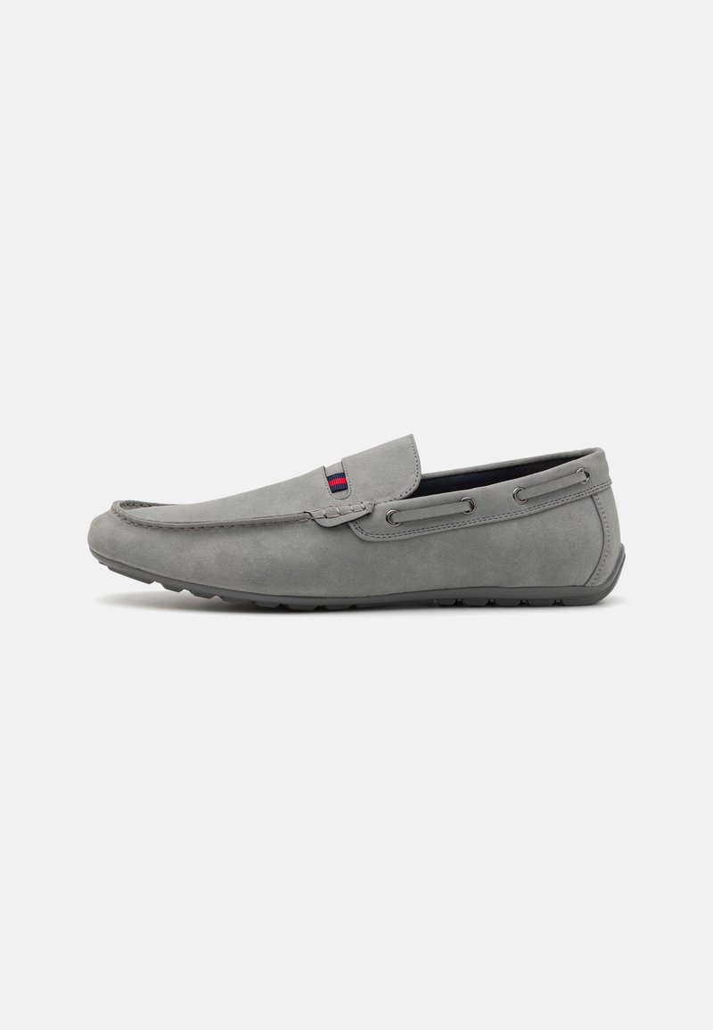 Gray suede slip-on shoe with a low profile, featuring a stitched detail, side accents, and a textured rubber sole.