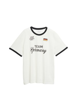 Biała koszulka z czarnym kołnierzem i krawędziami rękawów, napis „TEAM Germany”, mała niemiecka flaga i logo „Global Football Championship 2026” na klatce piersiowej.