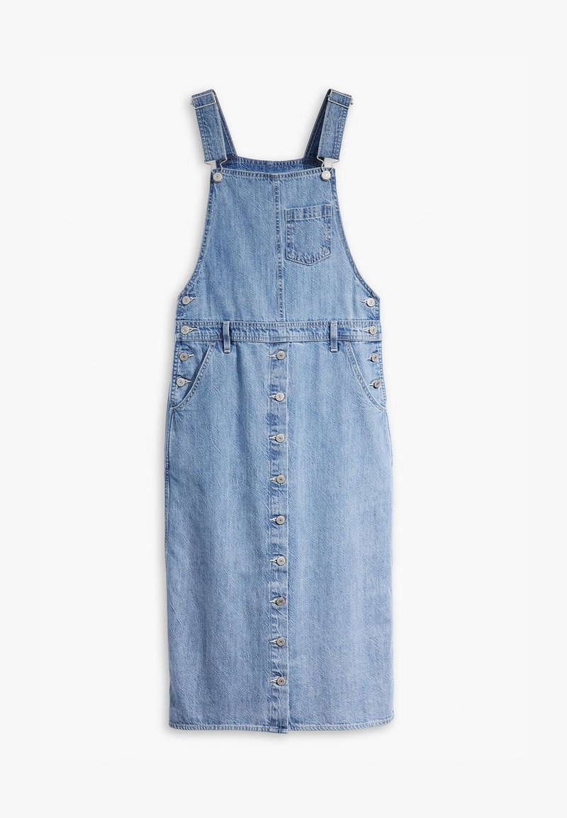 Robe salopette en denim bleu clair. Dotée de bretelles, d'une poche avant, d'une fermeture à boutons et de poches latérales. Texture vieilli.