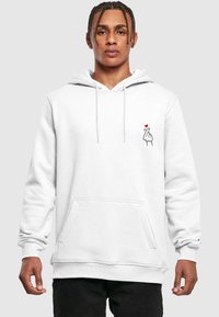 Vit hoodie med justerbara snoddar, ficka fram och handgrafik med ett rött hjärta tryckt på bröstet. Material av bomullsblandning.