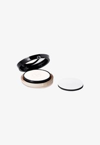 Estuche de polvo compacto negro con parte superior transparente, con una base beige. Incluye una esponja aplicadora blanca con borde negro.