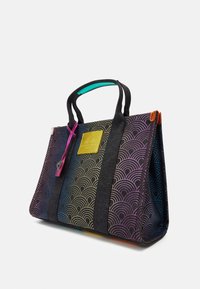 Texturerad toteväska med flerfärgad vågmönster, svart kropp, kontrasterande svarta handtag och en gul logopatch på framsidan.