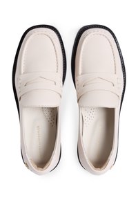 Λευκά δερμάτινα loafers με στρογγυλεμένη μύτη, διακοσμητικό ράψιμο και μαύρες λαστιχένιες σόλες. Διαθέτουν λεπτομέρεια λογότυπου σε χρυσό τόνο και διάτρητο εσωτερικό πάτο.