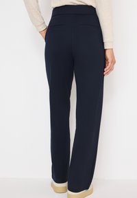 Marineblauwe broek in een recht model met een soepele textuur, voorzien van twee achterzakken en een comfortabele tailleband.