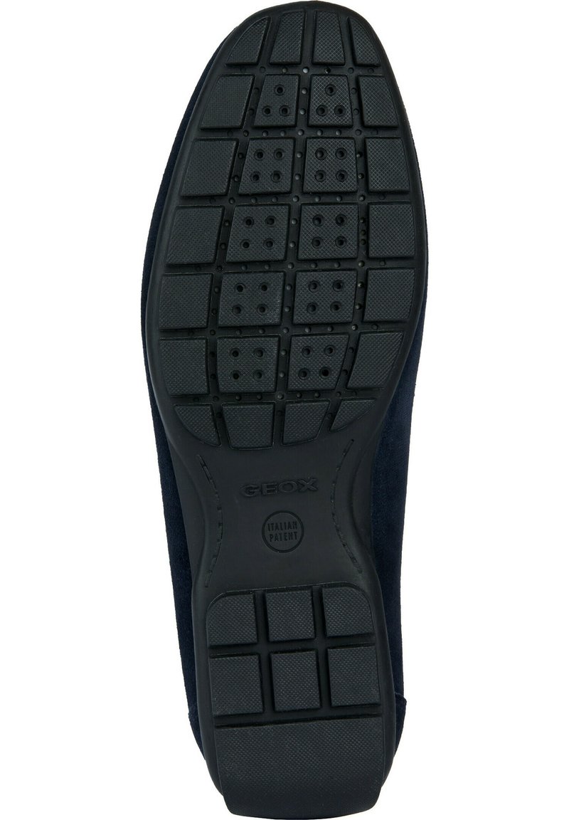 Semelle de chaussure noire en caoutchouc avec un motif de semelle comportant des rectangles surélevés et des perforations circulaires. Marque Geox dans la zone du talon.