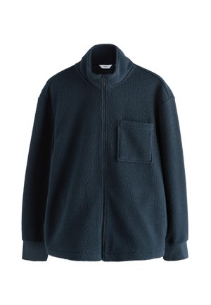 Giacca in pile blu navy scuro, con collo alto, zip frontale completa e tasca sul petto. Il tessuto ha un aspetto morbido e strutturato.
