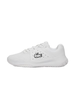 Witte sportieve schoenen met een gestructureerde bovenkant, vetersluiting en een prominent zwart krokodillenlogo aan de zijkant. Rubberen zool met een profielpatroon.