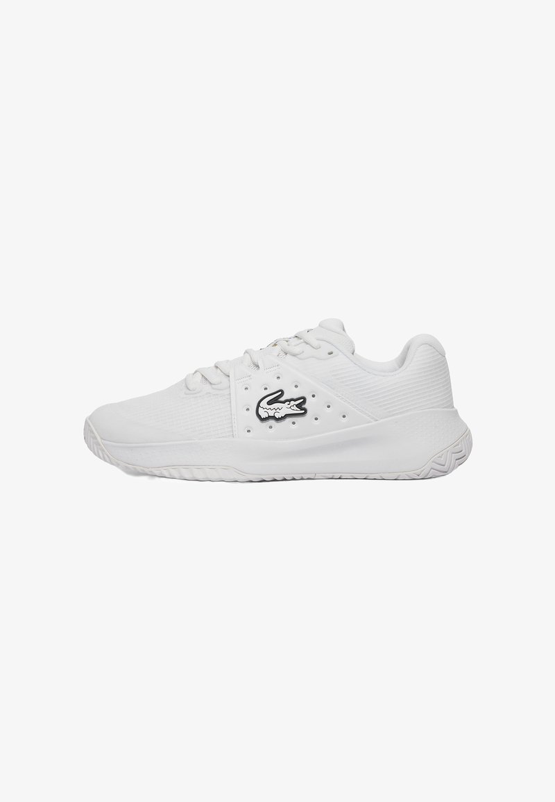 Chaussures de sport blanches avec une tige texturée, un design à lacets et un logo crocodile noir prominent sur le côté. Semelle en caoutchouc avec un motif de traction.