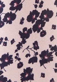 Tissu rose clair avec un motif de fleurs violet foncé, chacune ayant un petit centre blanc et rose, éparpillées sur la surface.