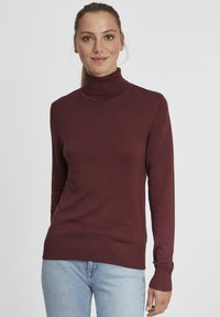 Burgunderfarget genser med høy hals i en glatt strikket stoff, med lange ermer, ribbestrikkede mansjetter og en noe avslappet passform. Kombiner med lys denim.