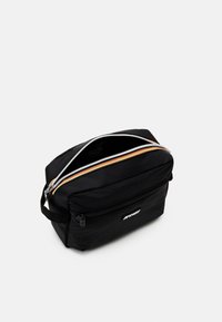 Black pouch bag with dual zippers, featuring orange and silver accents. Made of synthetic material, it has a soft texture and minimalist design.