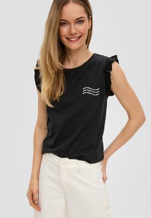 Schwarz Baumwoll-T-Shirt mit Rüschensäumen und weißem Textdesign, kombiniert mit hellen Jeans. Schlichte, legere Passform und Textur.