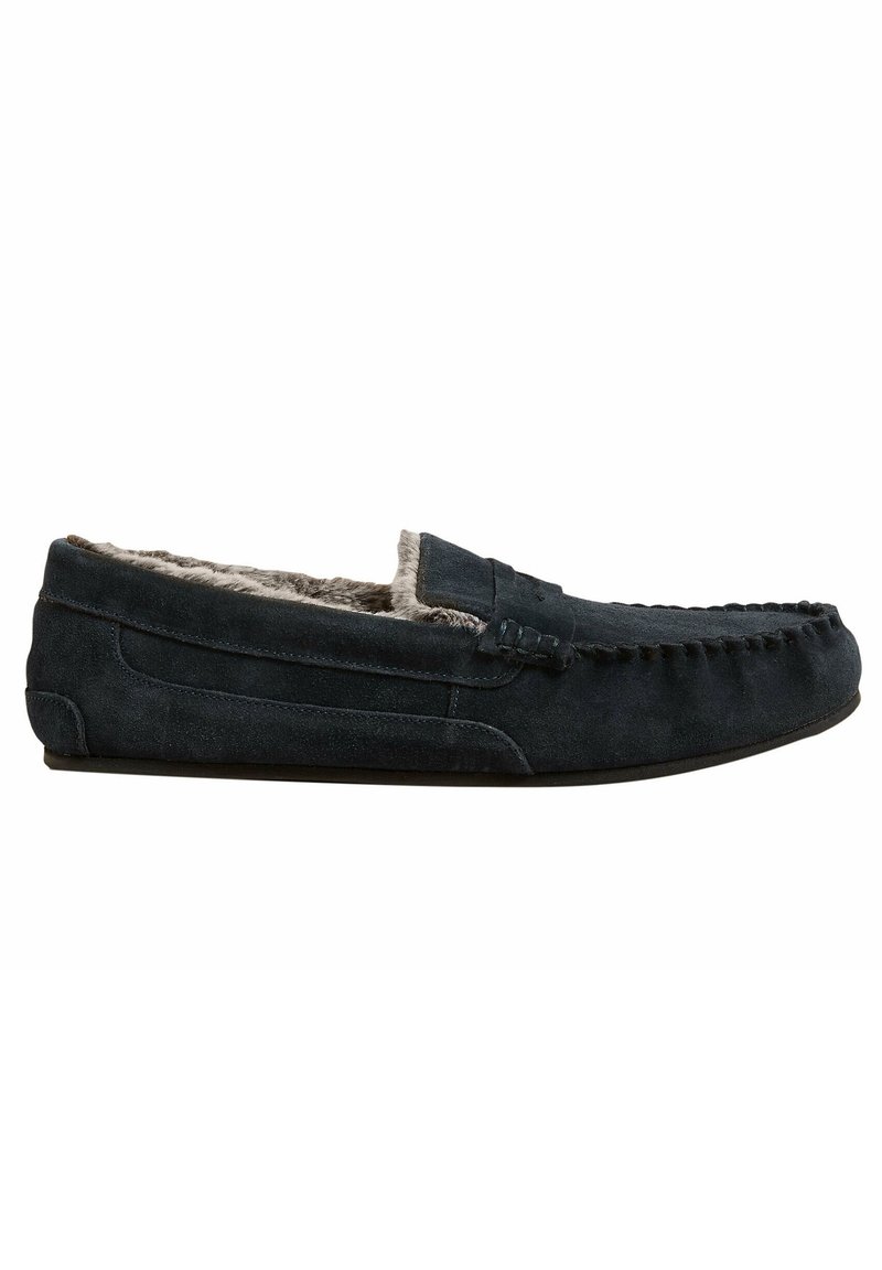 Mocassin en suède gris foncé pour homme avec détails cousus et doublure douce en fourrure grise, style slip-on à semelle plate.