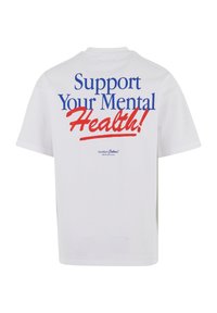 White cotton t-shirt featuring blue and red text on the back: “Support Your Mental Health!” with a cursive accent. Casual fit.