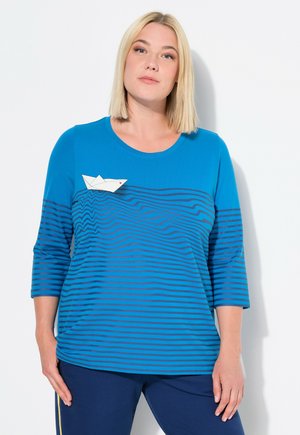 Maglietta a maniche lunghe a righe blu con scollatura tonda, caratterizzata da un'accenno di barchetta di carta bianca sul petto e una texture liscia e morbida.