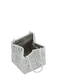 Hvid tekstureret taske med samlet design, blødt materiale, grå indvendig foring og runde håndtag. Firkantet form med åben top.