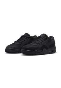 Chaussures de sport noires avec un mélange de matériaux en maille et en daim ; bout arrondi, lacets noirs épais, semelle en caoutchouc texturée et branding minimal.