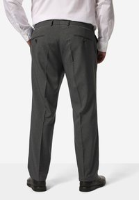 Grijze broek met een gestructureerde afwerking, voorpijpen en twee achterzakken; gecombineerd met zwarte dresschoenen. Perfecte pasvorm en strakke lijnen.