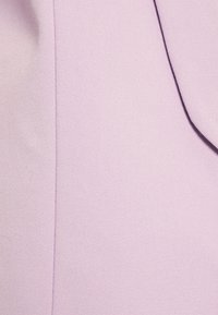 Tissu lilas avec un tissage fin et texturé ; surface lisse ; léger éclat ; comprend une ligne de couture sur le côté droit.