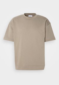 T-shirt beige à manches courtes en mélange de coton doux, doté d'un col rond, d'une coupe décontractée et d'un ourlet simple. Sans motifs ni accents visibles.