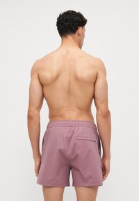 Men's swimming shorts in soft lavender, featuring an elastic waistband, single back pocket, and smooth, lightweight material.