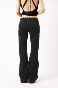 Čierne rozšírené džínsy vyrobené z pevného denimu, so zvýšeným pásom, dvoma zadnými vreckami a zipsom na zadnej strane.