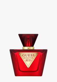 Bottiglia di profumo in vetro rosso con design triangolare, dettagli dorati e un'etichetta con il logo ben visibile che recita "GUESS Seductive RED."