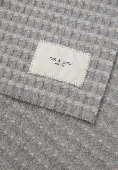 Hallikate, millel on tekstuuriline muster. Ühel nurgal on valge silt musta tekstiga "rag & bone NEW YORK".