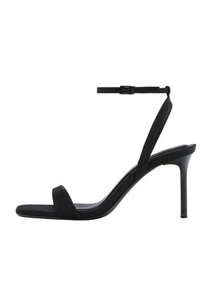 Čierna sandála na vysokom podpätku s tenkým remienkom okolo členka, otvorenou špičkou a štíhlym ihličkovým podpätkom, zobrazená z bočného profilu na bielom pozadí.