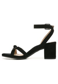 Black suede sandal featuring a wide strap design, a knotted detail at the front, and a block heel for stability. Adjustable ankle strap included.