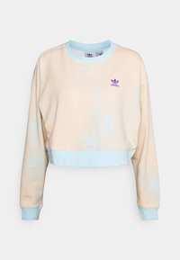 Felpa corta in un leggero pesca con un motivo sbiadito. Presenta un colletto e polsini a coste in verde mare. Piccolo logo Adidas viola sul petto.